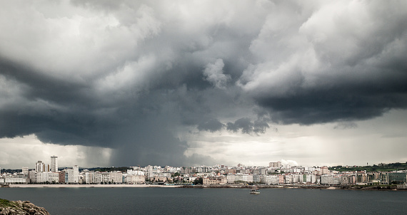 Heavy storm with rain and dramatic clouds over the city center of A Coruna, Northern Spain - Atlantic Ocean. Dark clouds with loads of heavy rain visible.