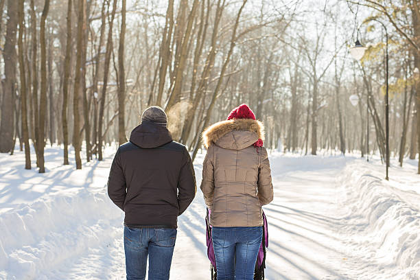 istock Young family walking with baby stroller in park 621367800