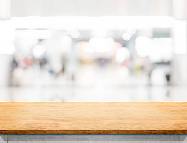 istock Empty wooden table and blurred shoppping mall bokeh light backgr 621370526