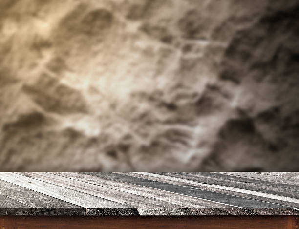 istock diagonal wooden plank table top at blurred rough stone wall 621370626