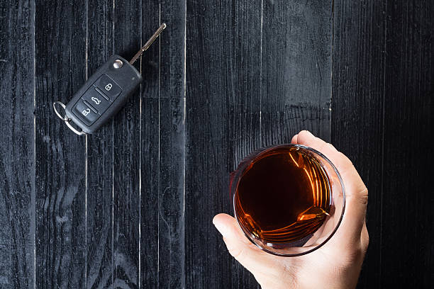 автомобильный ключ и виски алкогольный напиток в стакане на - designated driver стоковые фото и изображения