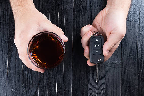 автомобильный ключ и виски алкогольный напиток в стакане на - designated driver стоковые фото и изображения