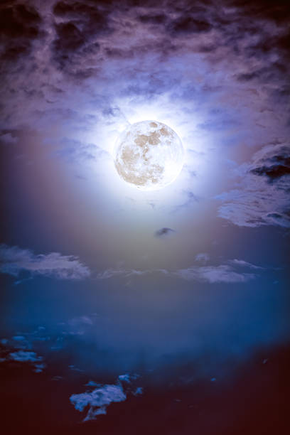 istock Nighttime sky with clouds and bright full moon with shiny. 621372300