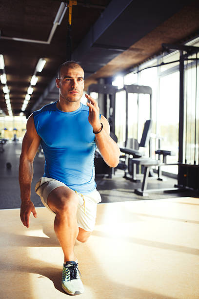 istock Man doing leg exercises with suspension straps at gym. 621372792