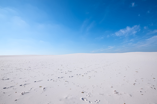 Wonderful landscape - white sand dunes of the desert on a background of blue sky. Wide angle.