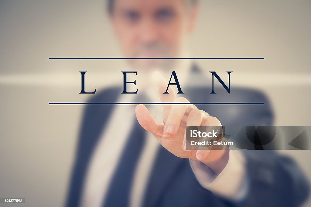 Business man adopting Lean methodology a Business man in a suit touching word "Lean" Leaning Stock Photo