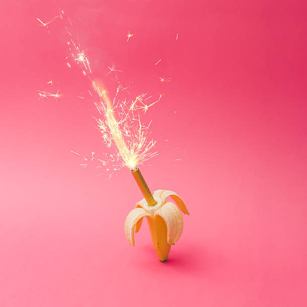 Banana fruit with firework candle on pink background. Celebratio