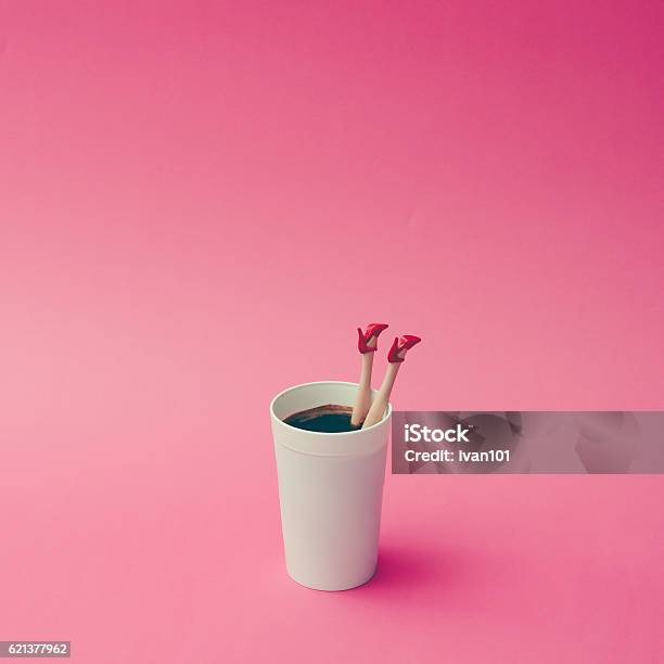 Coffee Cup With Female Doll Legs On Pink Background Stock Photo - Download Image Now