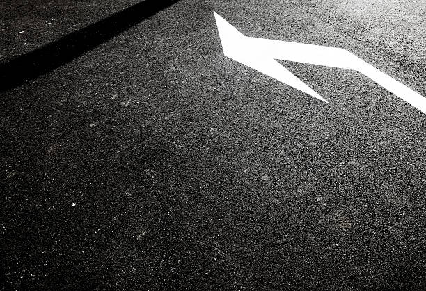 turn arrow painted in white on a black asphalt road