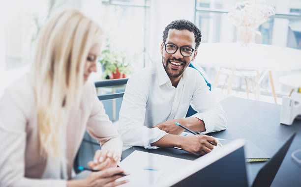 istock Two young coworkers working together in a modern office.Black 621378120