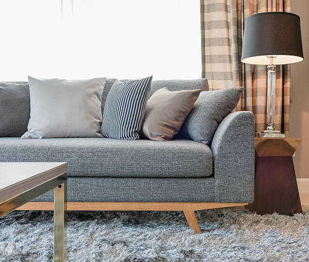 istock row of pillows on grey sofa with black lamp 621378674