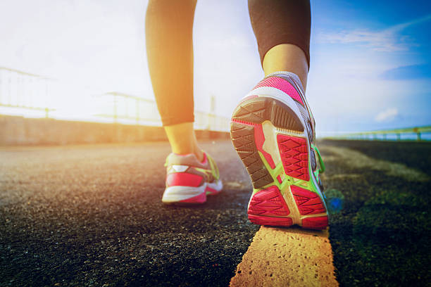 istock Athlete runner feet running on road closeup on shoe 621378818