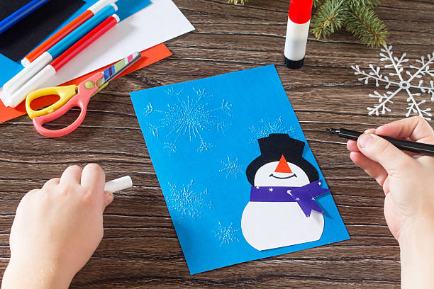 istock The child makes a greeting card with a snowman. 621379240