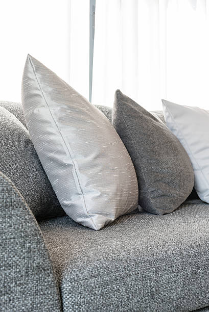 istock row of pillows on grey sofa with black lamp 621379306