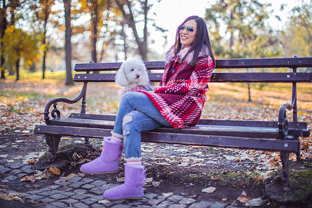 istock Woman sitting with her dog on bench 621380450
