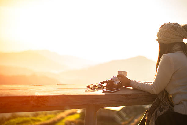 istock Woman drinking coffee in sun sitting outdoor 621380578