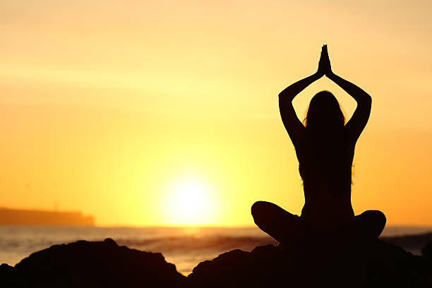 istock Woman silhouette doing yoga exercises 621383268