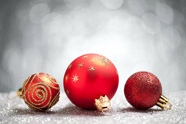 istock Red christmas baubles on silver glitter with grey background 621383292