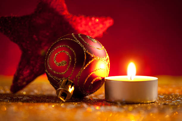 istock Candle and baubles on glitter with red background 621383460