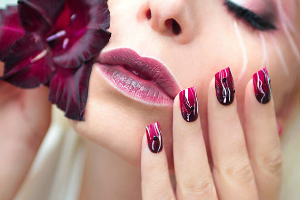 istock Burgundy manicure with gladiolus. 621383668