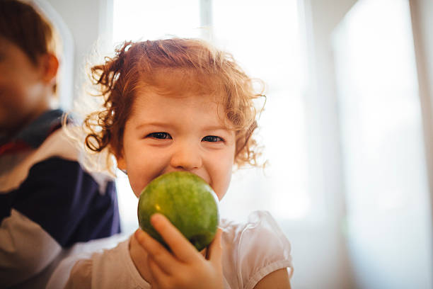 私のおいしいグリーンアップル - child eating apple fruit ストックフォトと画像