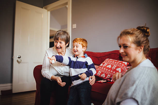 extended family at home together - mother holding child pointing imagens e fotografias de stock