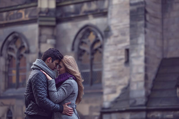 Bride nad groom kissing in front of abandoned old church