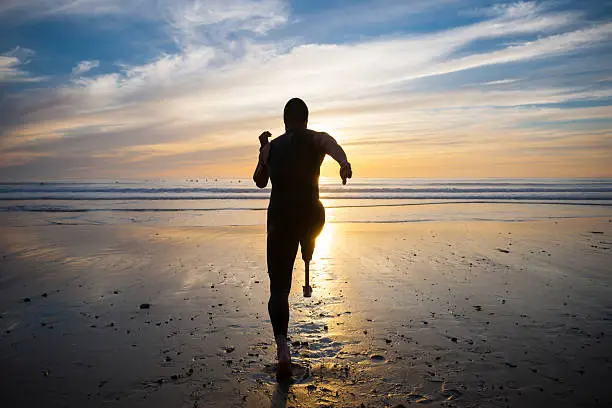 Photo of Silhouette Of Athlete With Prosthetic Leg On The Beach