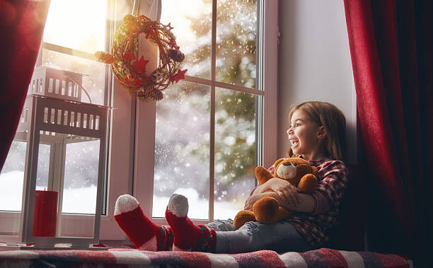 istock girl sitting by the window 621387772