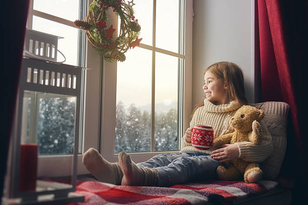 istock girl sitting by the window 621387936