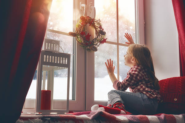 istock girl sitting by the window 621388114