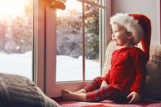 istock baby girl sitting by the window 621388206