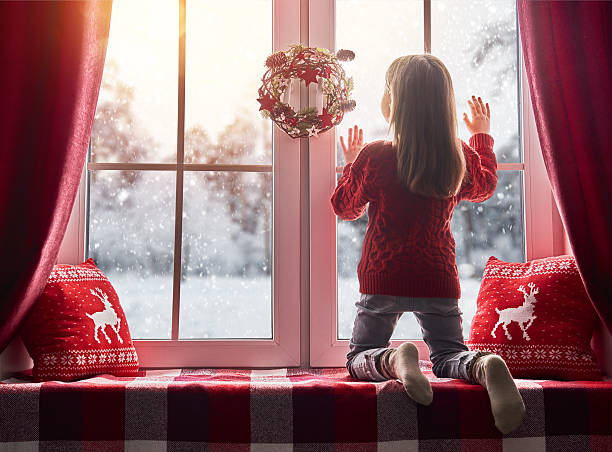 istock girl sitting by the window 621388394