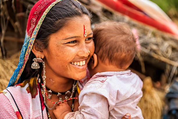 junge indische mutter hält ihr kleines baby, village nahe reithose - poverty india child little girls stock-fotos und bilder