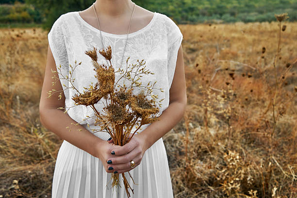Concept vintage avec une jeune femme tenant un bouquet - Photo