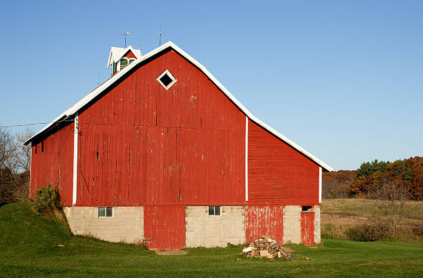istock Red barn and woodpile 621392912
