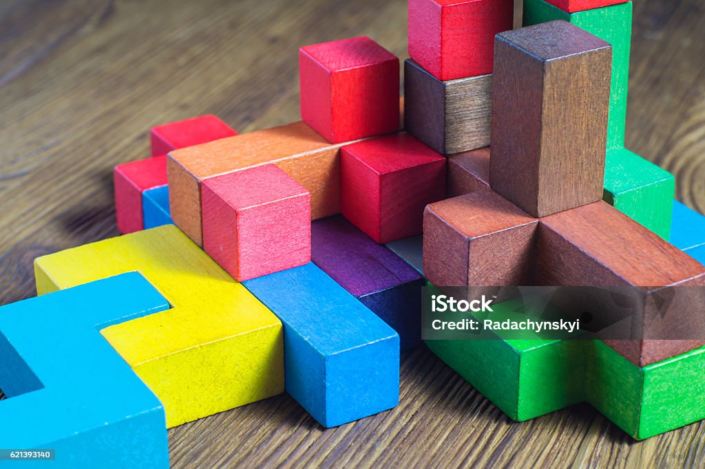 Colorful wooden building blocks. Abstract construction from wooden blocks game shapes. The concept of logical thinking, geometric shapes. Colorful wooden building blocks. Toy Block Stock Photo