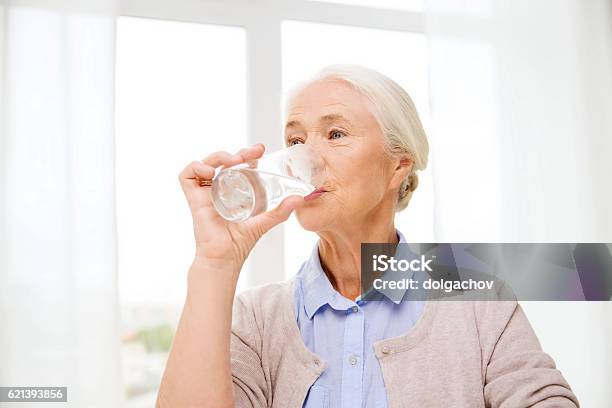 Happy Senior Woman With Glass Of Water At Home Stock Photo - Download Image Now - Senior Adult, Drinking Water, Drinking