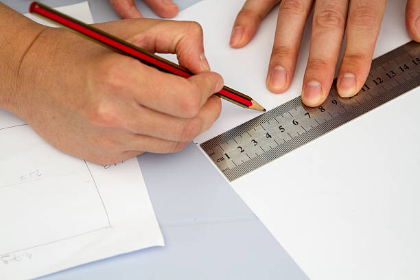 istock hands holding ruller and pencil over sheme on the table 621461286