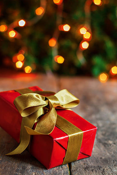 istock wrapped gift on the background of Christmas lights 621464898