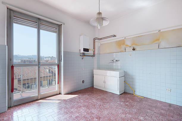 istock Old empty kitchen room with tiled floor and walls 621465134