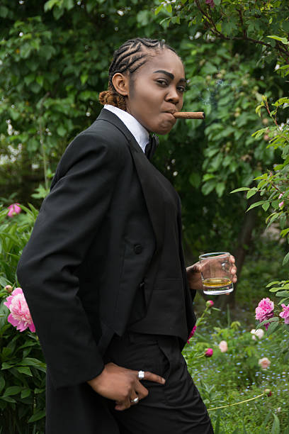 giovane donna nera in resistenza maschile, vista laterale in piedi all'aperto. - smoking women smoke smoking issues foto e immagini stock