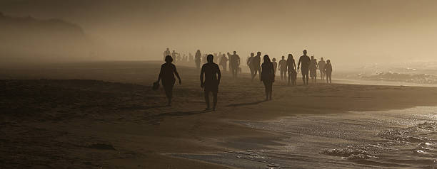 Two Unrecognizable People Standing At The End Of A Foggy Pier