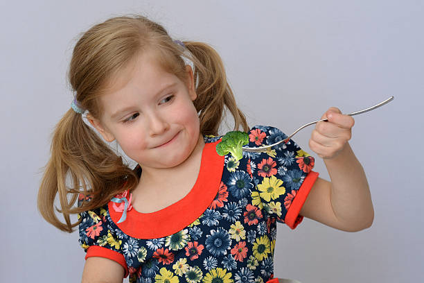 istock Child, kid, baby (little girl) doesn't want to eat broccoli. 621473462