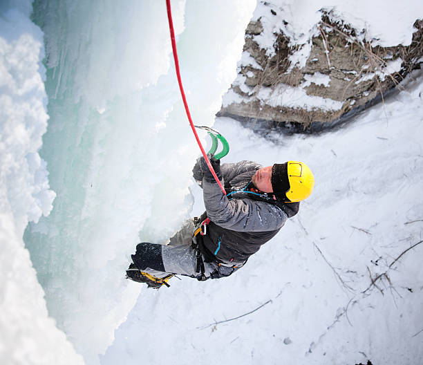 istock Man climbing frozen waterfall 621475418