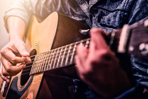 istock woman's hands playing acoustic guitar 621475480