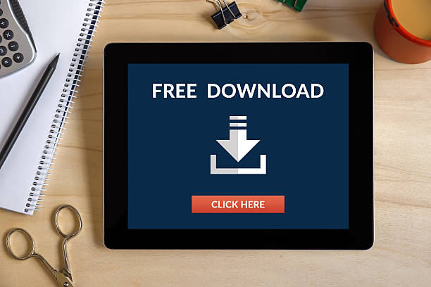 concept de téléchargement gratuit sur l’écran de la tablette avec des objets office - costless photos et images de collection