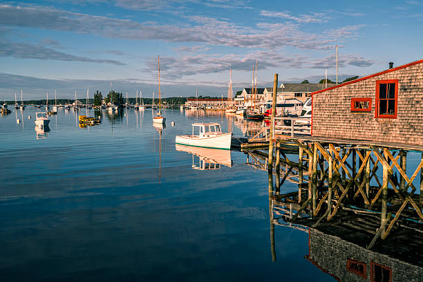 A wooden shelf provides a dry landing for small boats in a New England harbor.