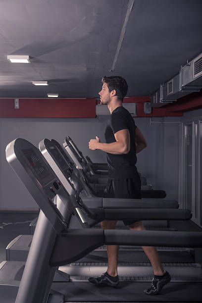 istock young man running treadmill, indoors gym. 621479480
