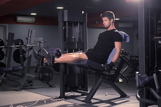 istock young man sitting leg extension gym 621479806